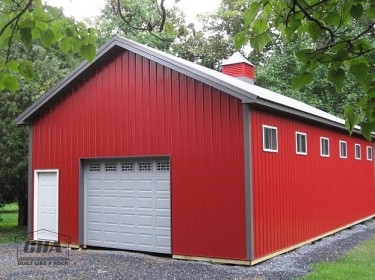 a red pole barn with a cupola and door