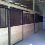 the interior of a pole barn used as a horse barn